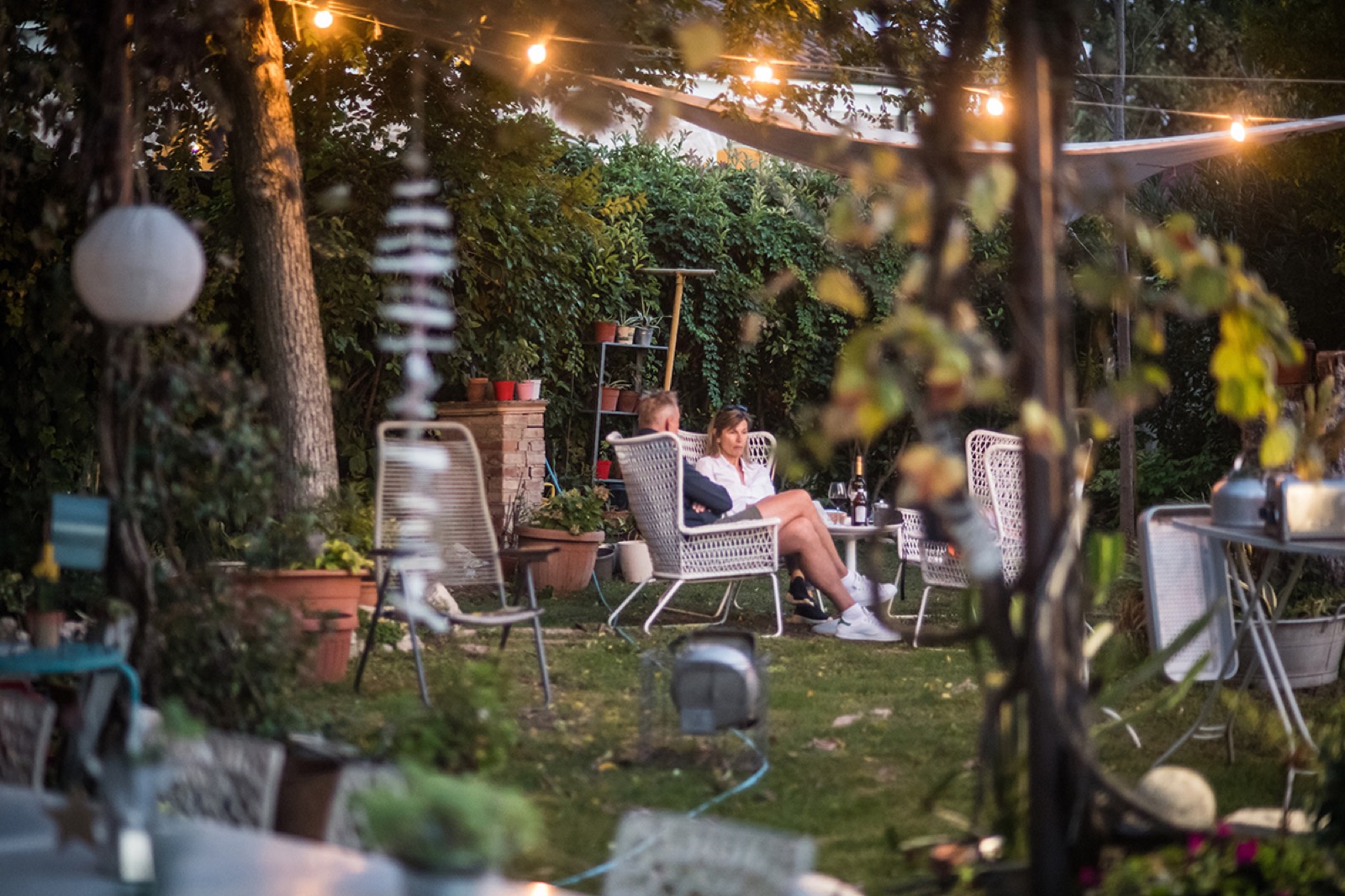 Salotto in giardino con luci scintillanti al calar della sera