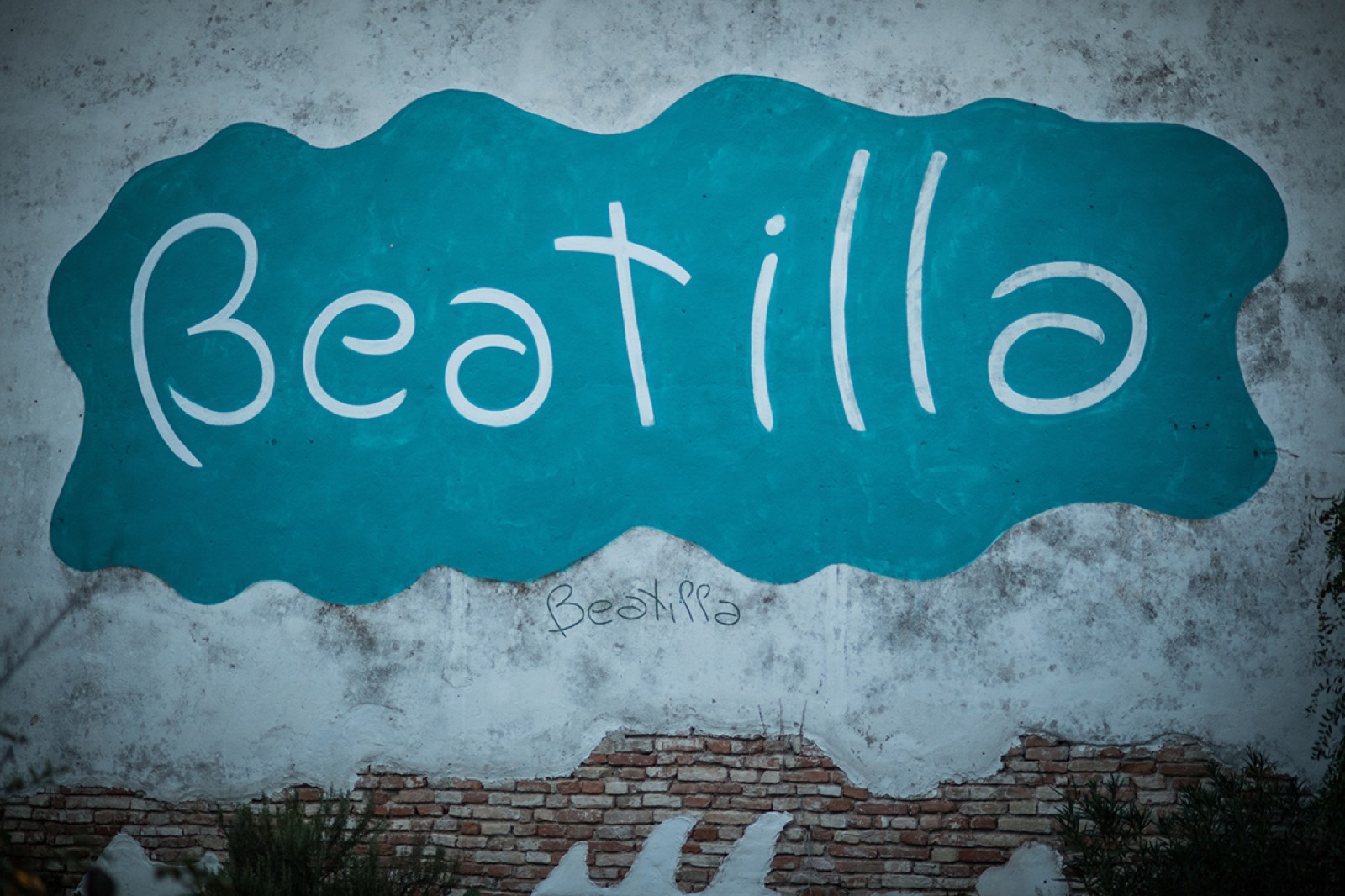 La scritta Beatilla dipinta a mano sul muro della cascina