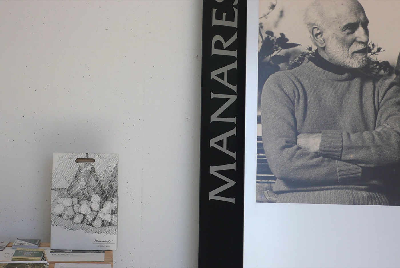 Il ritratto di Paolo Manaresi accanto all'insegna della cantina, con un'incisione dell'artista